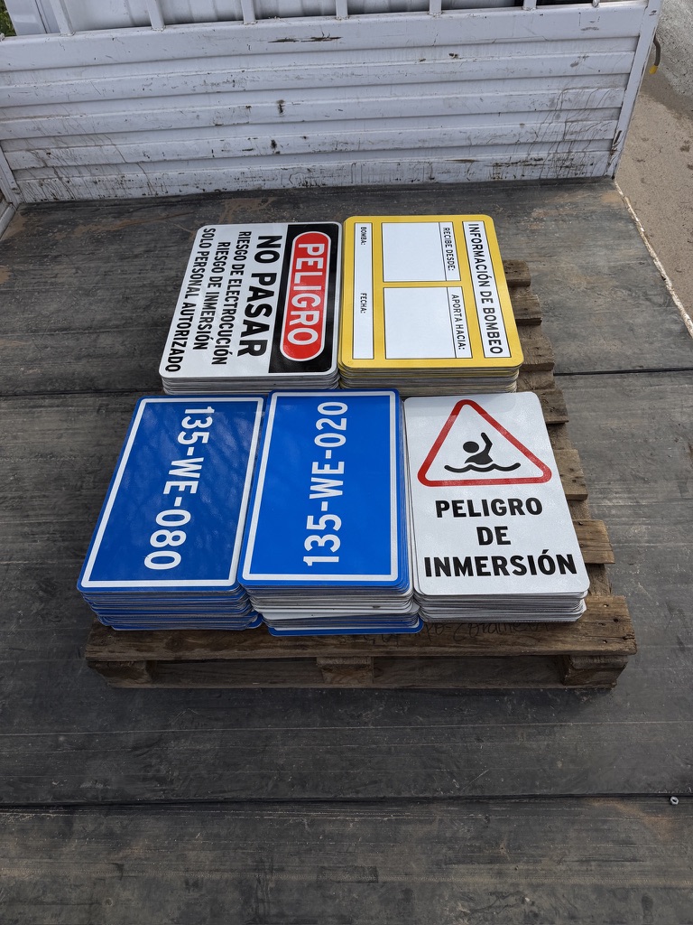 Lote de letreros galvanizados reflectivos para Minera Candelaria, apilados sobre un pallet
